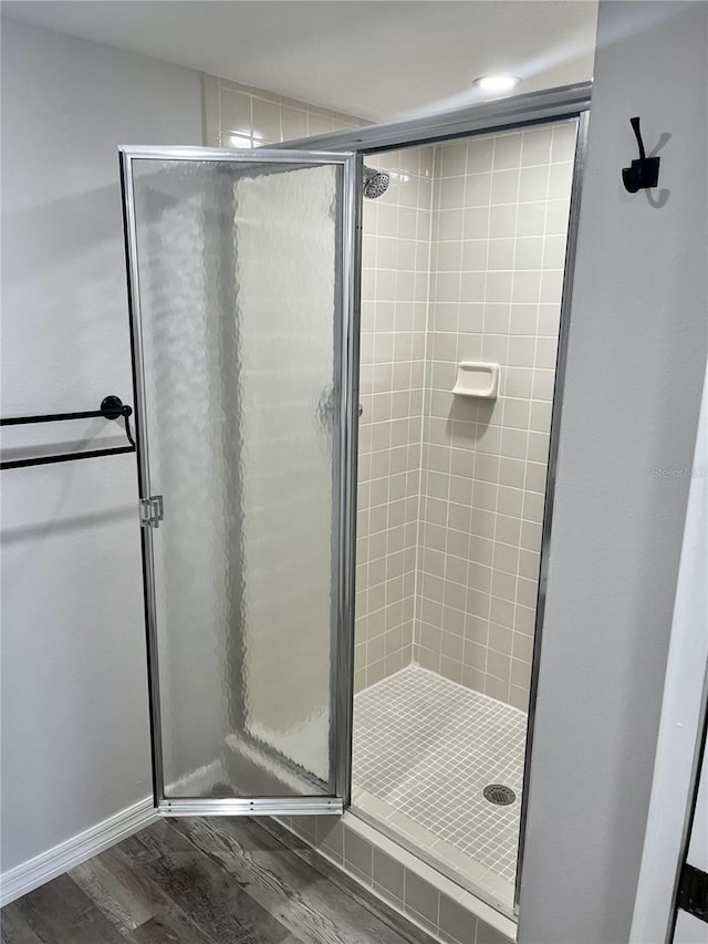 bathroom with hardwood / wood-style floors and a shower with door