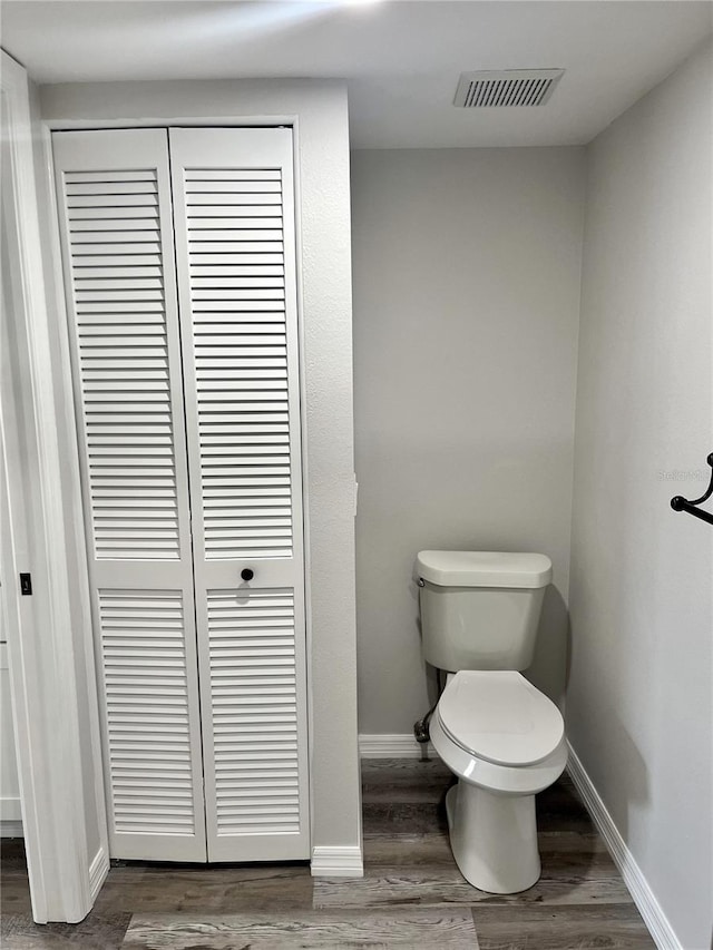 bathroom featuring wood-type flooring and toilet