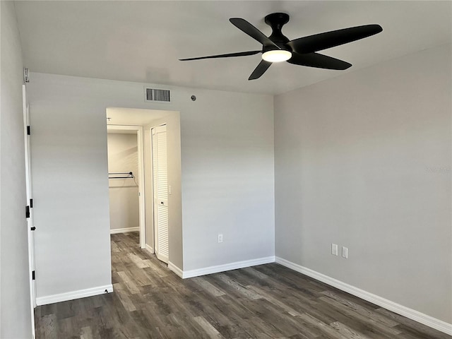 spare room with dark hardwood / wood-style flooring and ceiling fan