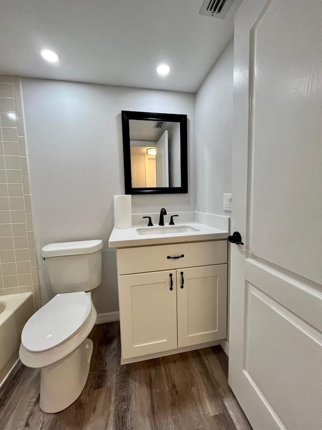 full bathroom with wood-type flooring, vanity, toilet, and tub / shower combination