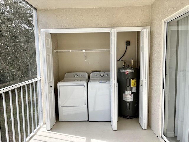 clothes washing area featuring independent washer and dryer and electric water heater