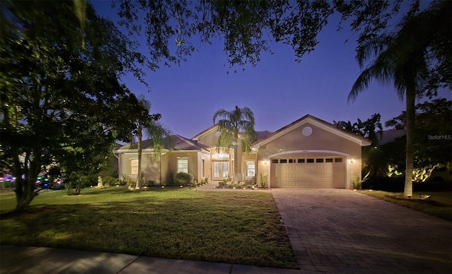 single story home with a garage and a yard