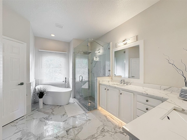 bathroom with vanity, separate shower and tub, and a textured ceiling