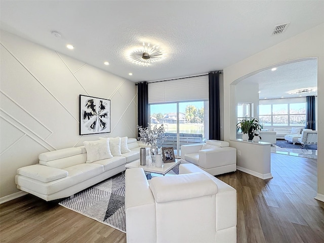 living room featuring dark wood-type flooring and a textured ceiling