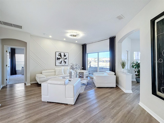 living room featuring a textured ceiling and light hardwood / wood-style flooring