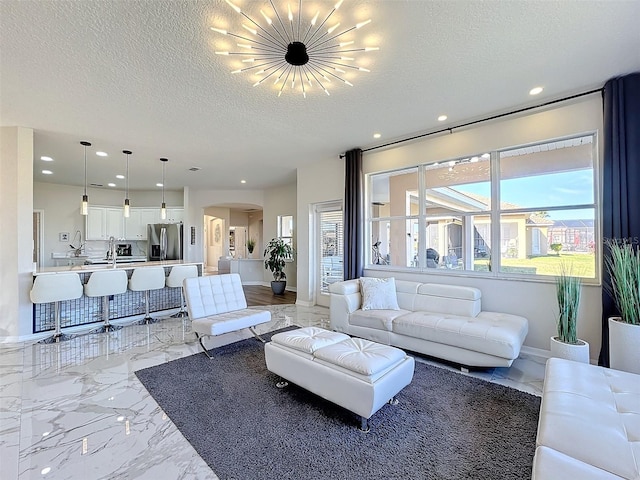 living room featuring an inviting chandelier and a textured ceiling