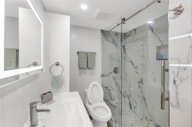 bathroom featuring toilet, a shower with door, and sink