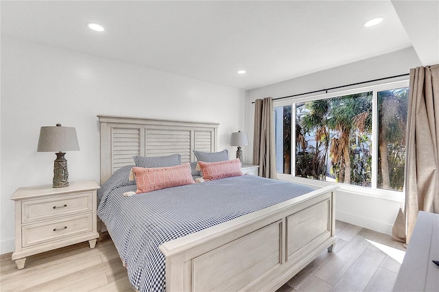 bedroom with light hardwood / wood-style floors and multiple windows