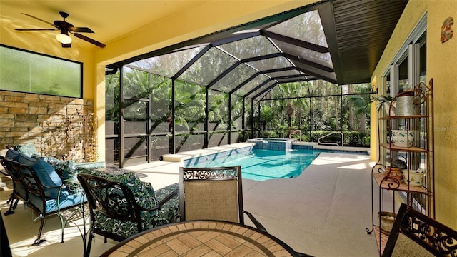 view of pool with glass enclosure, ceiling fan, and a patio