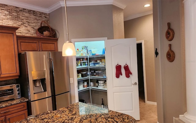 kitchen with dark stone counters, ornamental molding, pendant lighting, light tile patterned floors, and stainless steel fridge with ice dispenser