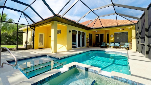 view of swimming pool featuring an in ground hot tub, glass enclosure, ceiling fan, and a patio area