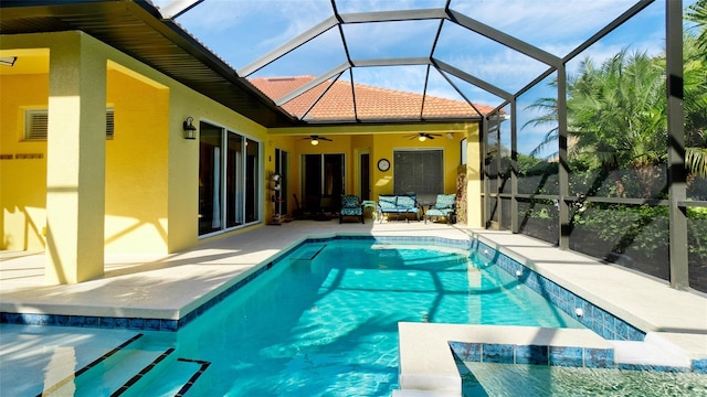 view of pool with glass enclosure, ceiling fan, and a patio area