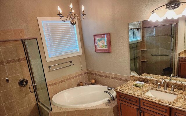 bathroom featuring vanity, a chandelier, and shower with separate bathtub