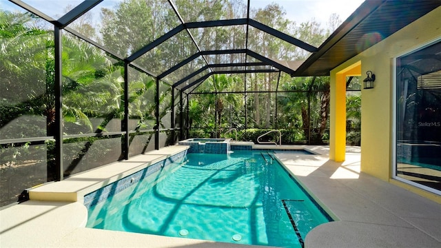 view of pool featuring glass enclosure, a patio area, and an in ground hot tub