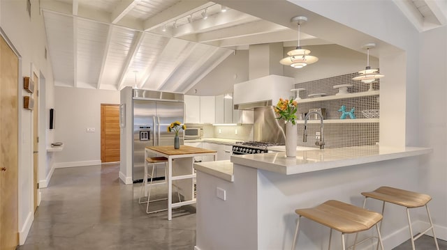 kitchen featuring built in fridge, white cabinets, exhaust hood, and kitchen peninsula