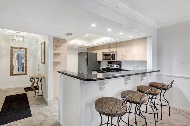 1200 E Peppertree Ln Unit 607, Sarasota, FL 34242 - kitchen with stainless steel appliances, a breakfast bar, dark countertops, crown molding, and light tile patterned flooring