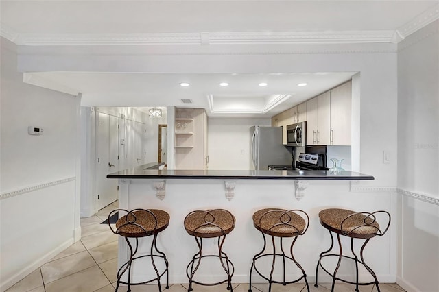 1200 E Peppertree Ln Unit 607, Sarasota, FL 34242 - kitchen with appliances with stainless steel finishes, dark countertops, a kitchen breakfast bar, a peninsula, and crown molding