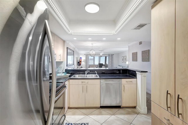 kitchen with kitchen peninsula, appliances with stainless steel finishes, ornamental molding, a raised ceiling, and sink