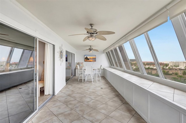 unfurnished sunroom with ceiling fan