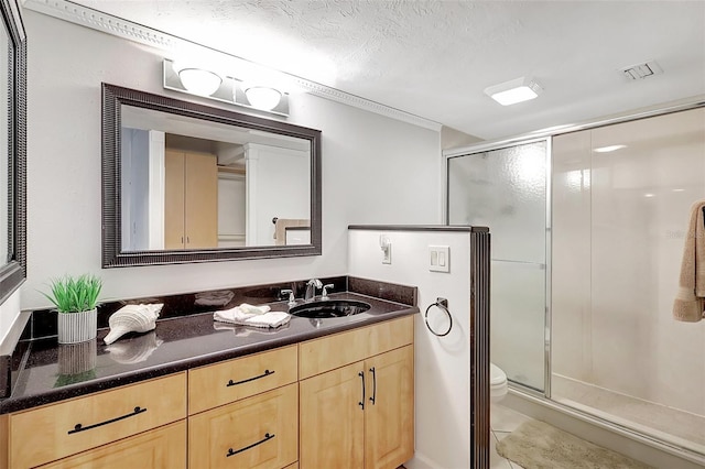 bathroom featuring vanity, toilet, a textured ceiling, and walk in shower