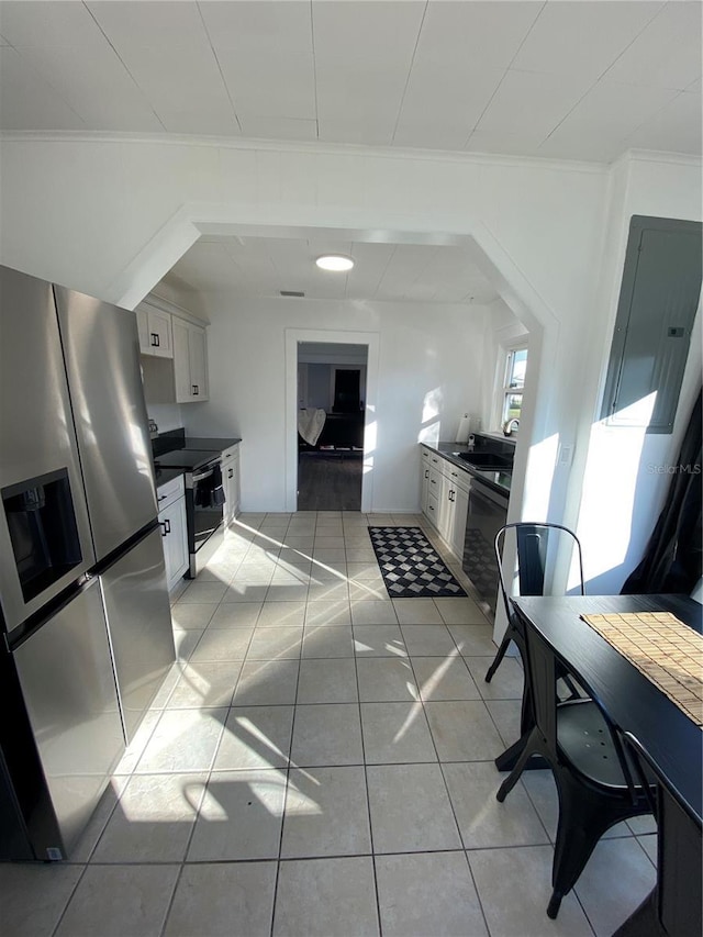 kitchen featuring light tile patterned floors, stainless steel appliances, white cabinetry, and sink