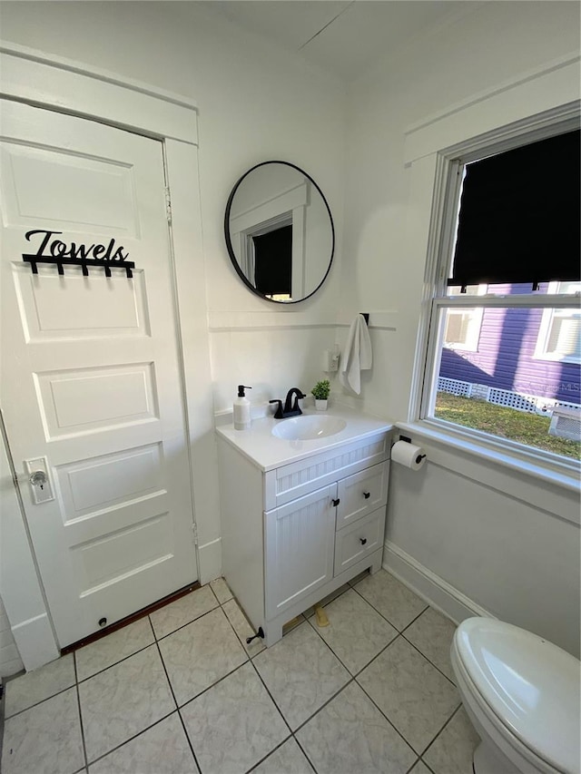 bathroom with toilet, vanity, and tile patterned floors