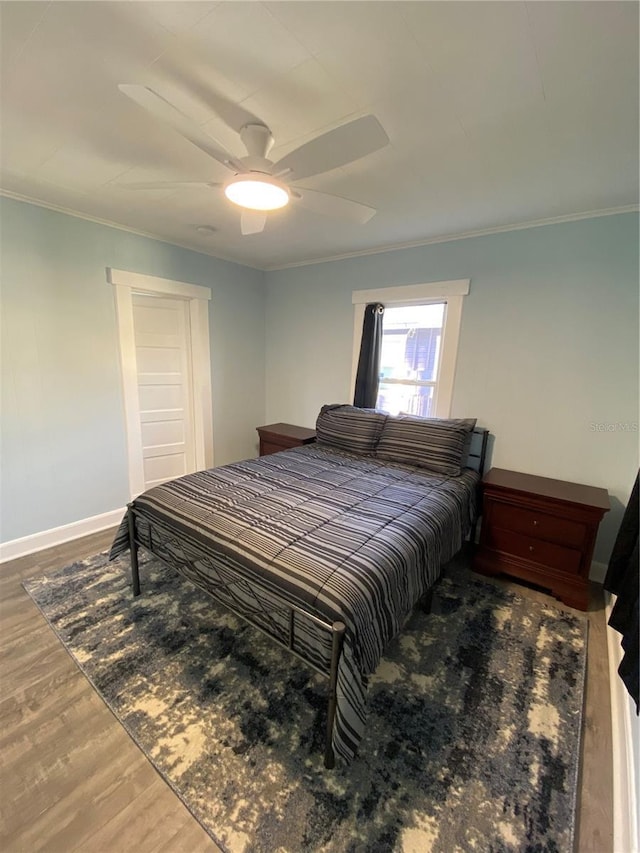 bedroom with hardwood / wood-style flooring, ceiling fan, and crown molding