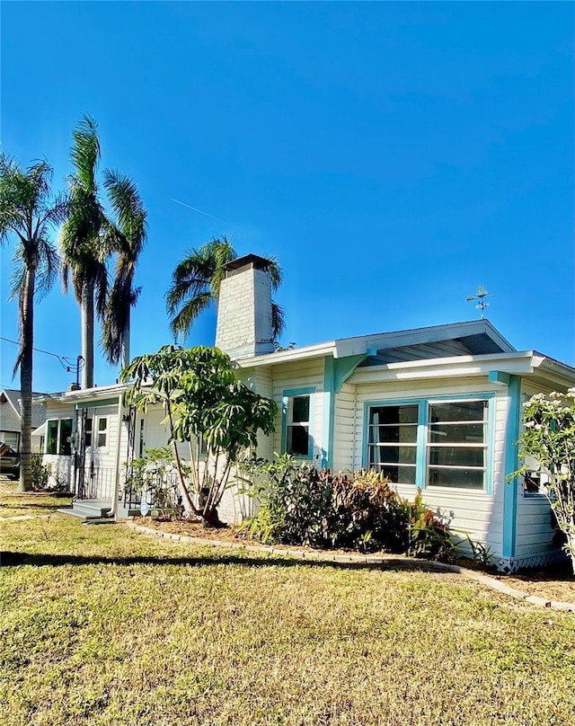 222 27th St W, Bradenton, FL 34205 - view of side of home with a chimney and a yard