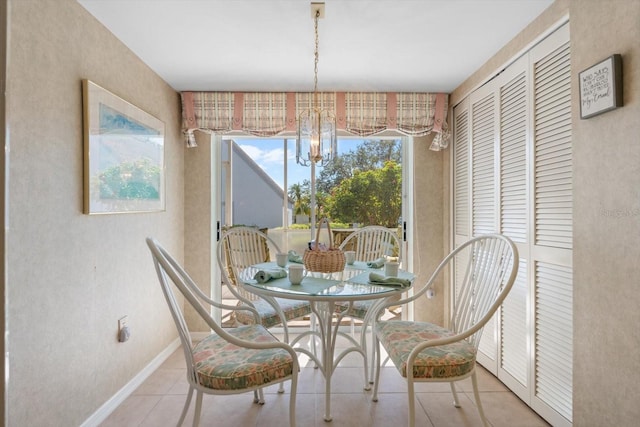 dining area featuring tile patterned flooring and a notable chandelier