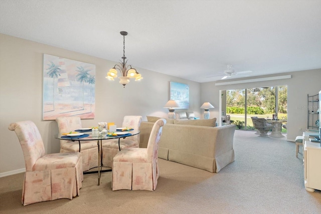 carpeted dining room with ceiling fan with notable chandelier