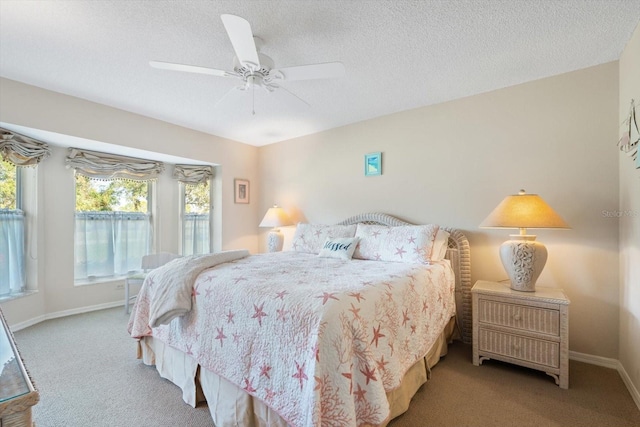 bedroom with a textured ceiling, light colored carpet, and ceiling fan