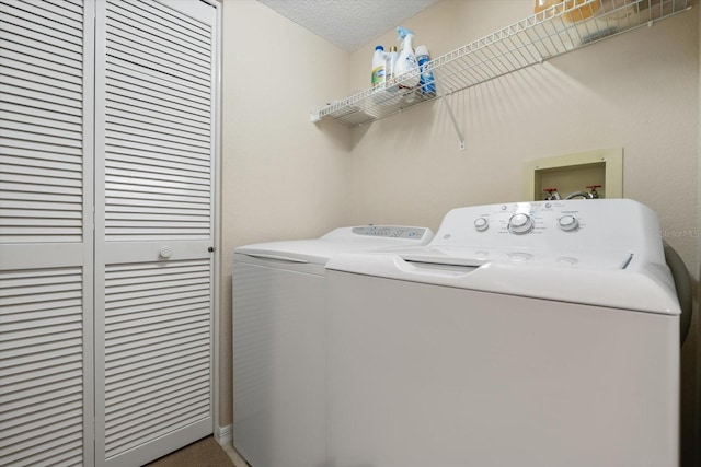 laundry room with washer and clothes dryer and a textured ceiling