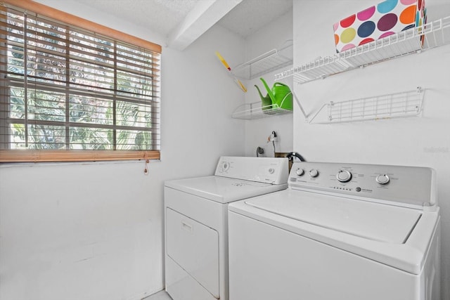 laundry room with separate washer and dryer and a textured ceiling