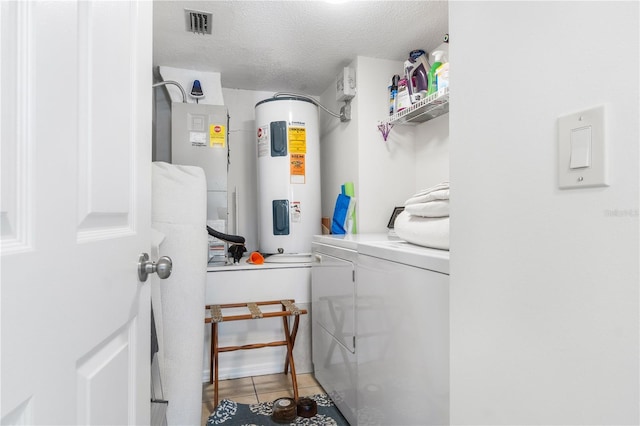 washroom with tile patterned flooring, a textured ceiling, electric water heater, and separate washer and dryer