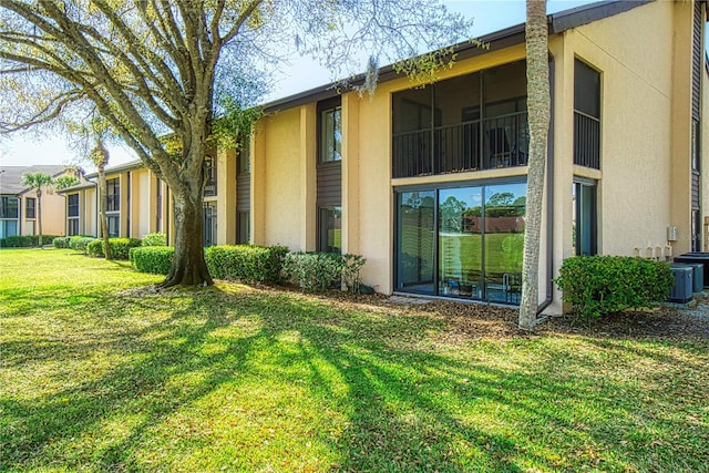 exterior space with central air condition unit and a lawn