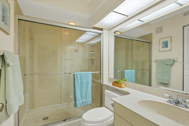 bathroom featuring vanity, toilet, and a shower with door