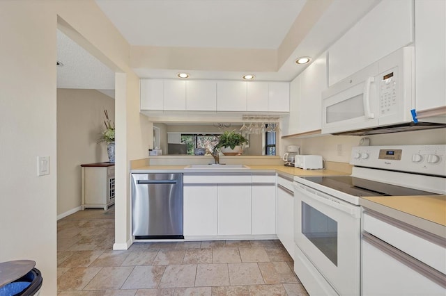 kitchen featuring kitchen peninsula, sink, white cabinets, and white appliances