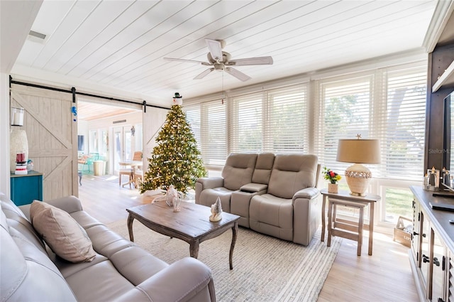 living room featuring a barn door, ceiling fan, light hardwood / wood-style flooring, and wood ceiling