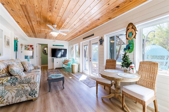 living room featuring ceiling fan, french doors, wooden ceiling, wood walls, and wood-type flooring