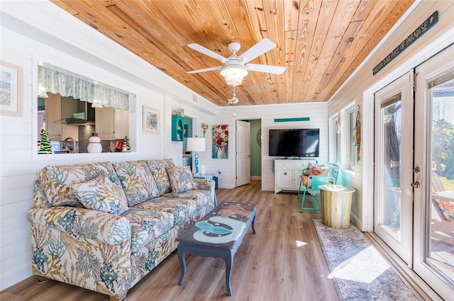 living room with ceiling fan, sink, light hardwood / wood-style flooring, wooden walls, and wood ceiling