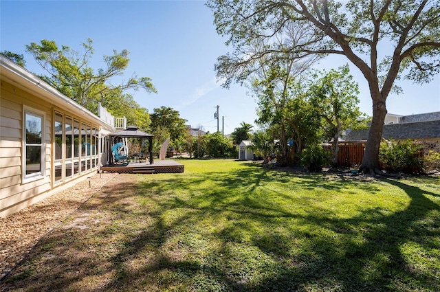 view of yard featuring a gazebo, a shed, and a wooden deck