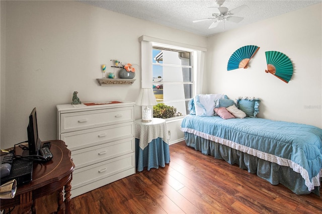 bedroom with ceiling fan, dark hardwood / wood-style flooring, and a textured ceiling