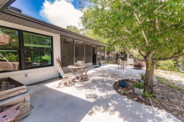 view of patio / terrace featuring a fire pit and a sunroom