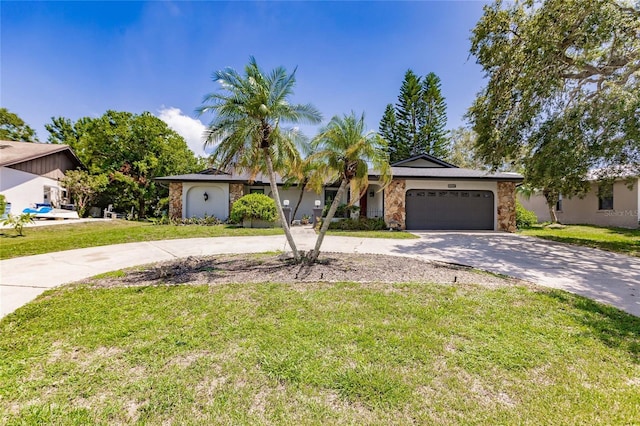 7707 10th Ave NW, Bradenton, FL 34209 - ranch-style home featuring curved driveway, stone siding, a garage, and a front lawn