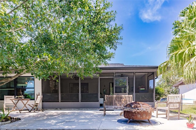 7707 10th Ave NW, Bradenton, FL 34209 - rear view of house featuring a sunroom, a fire pit, and a patio area
