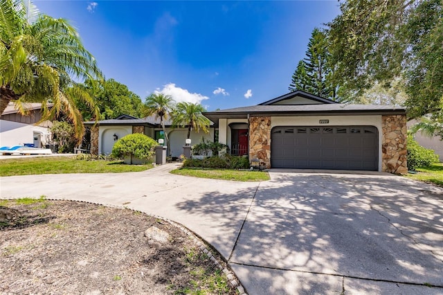 7707 10th Ave NW, Bradenton, FL 34209 - ranch-style house with driveway, a garage, and stone siding