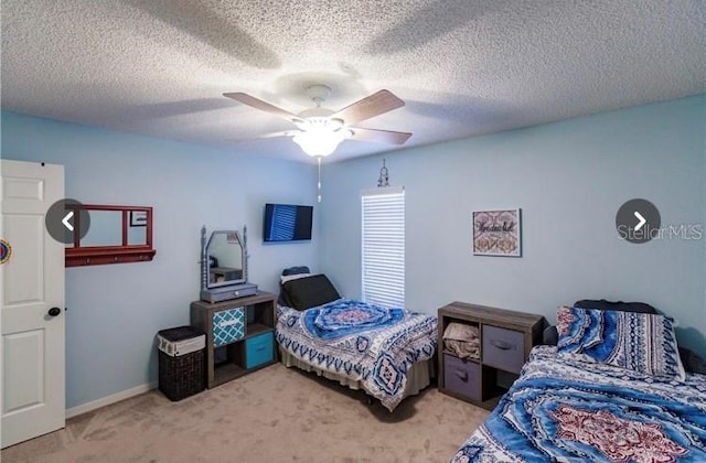 bedroom with ceiling fan, carpet floors, and a textured ceiling