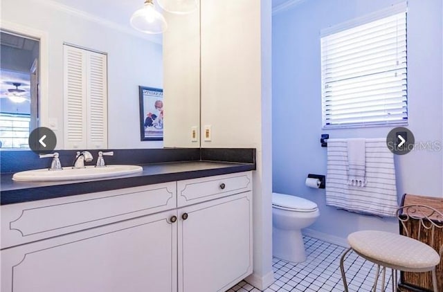 7707 10th Ave NW, Bradenton, FL 34209 - bathroom with toilet, vanity, crown molding, tile patterned floors, and baseboards