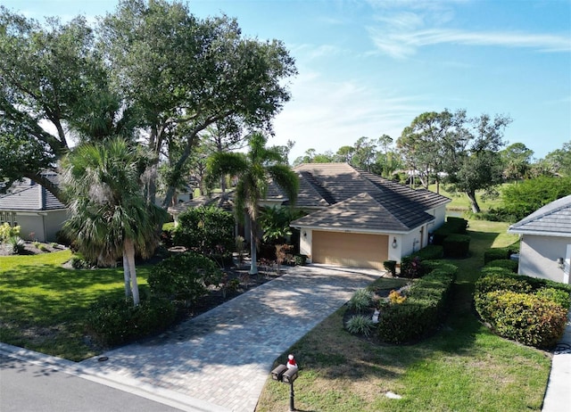 single story home with a garage and a front lawn