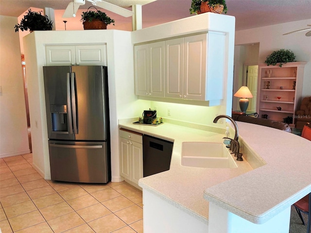 kitchen featuring a breakfast bar, sink, light tile patterned floors, kitchen peninsula, and stainless steel appliances